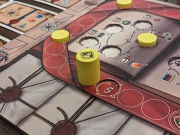 Een detailopname van een strategisch bordspel met gele houten speelstukken op een mooi geïllustreerd kartonnen spelbord.